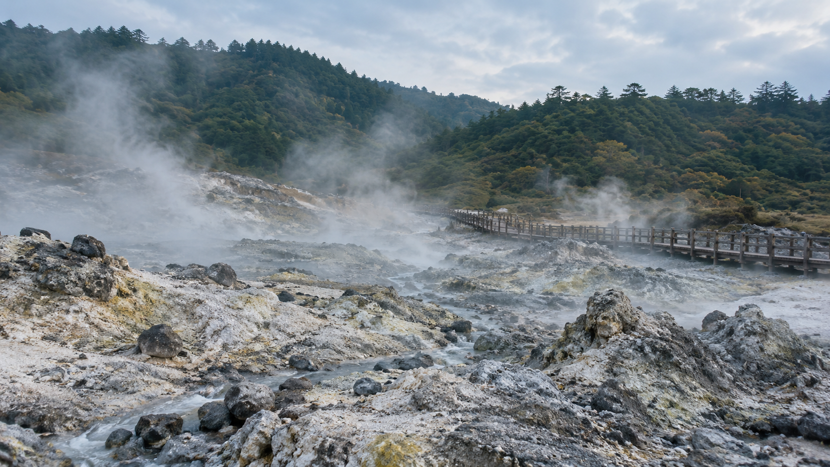 湯けむりが立つ山あいの温泉地のイメージ。生成画像で、玉川温泉の実景ではありません
